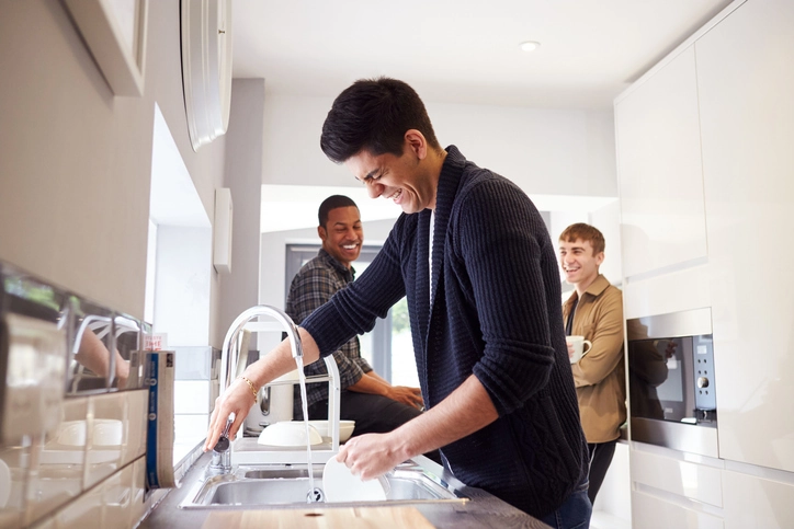 Roommates share cleaning chores in assisted transitional adult living, such as Telos U