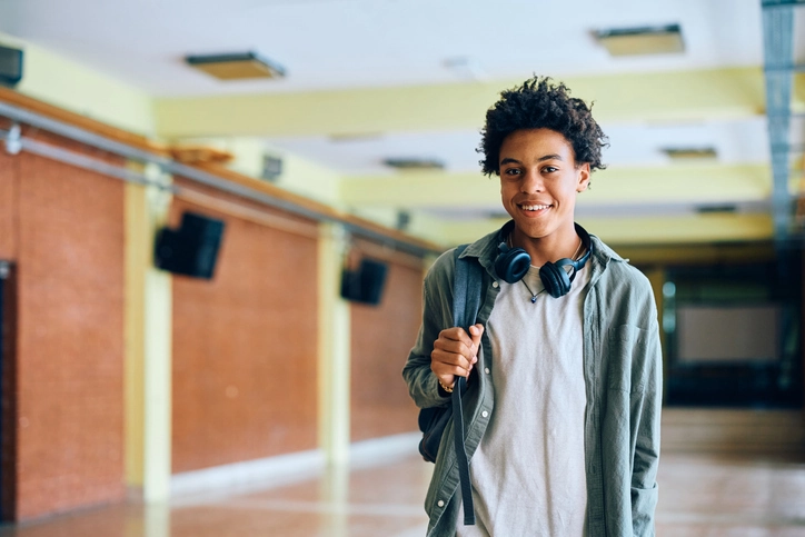 A teenage boy smiles in the hallway of a therapeutic boarding school